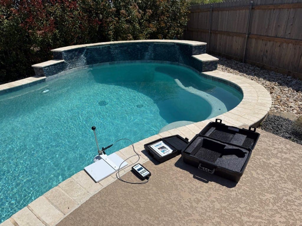 Close-up of waterline tile and pebble finish during pool inspection — Leander