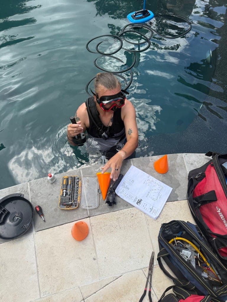 Diver with hydrophone and blueprints during pool leak detection — Georgetown