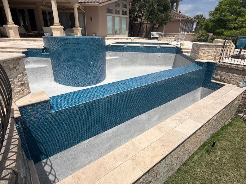 Pool renovation crew applying new plaster finish in Central Texas
