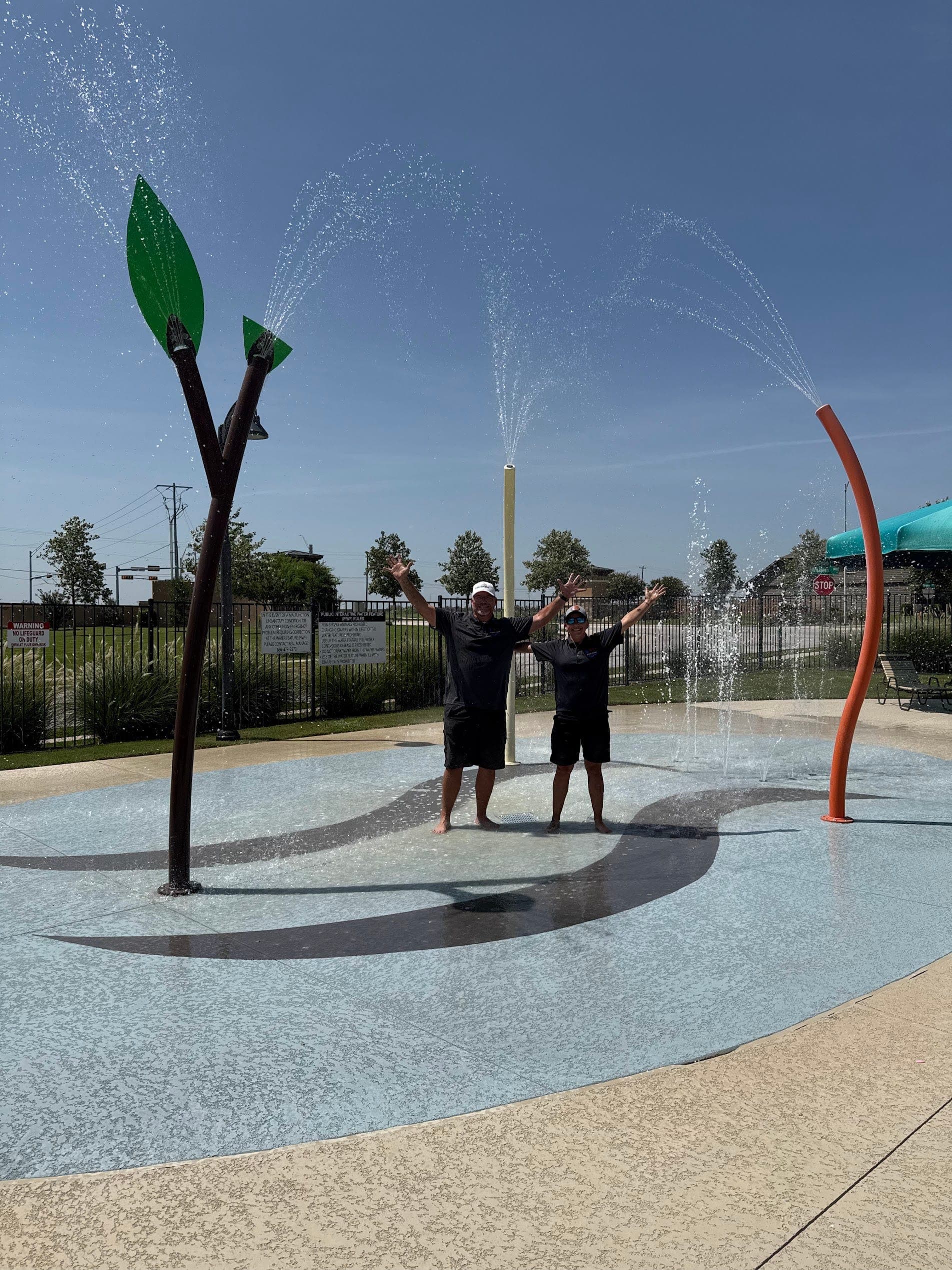 911 Pool Care team celebrating a completed splash pad project